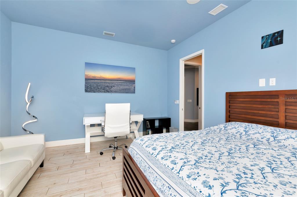 28154 Gopher Hill Road Myakka City, FL 34251 - Photo 83 of 100 a bedroom with a large bed and a lamp