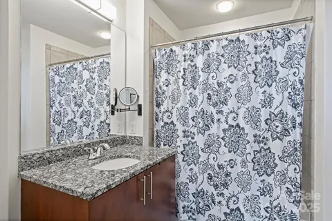 a bathroom with a granite countertop sink and a shower