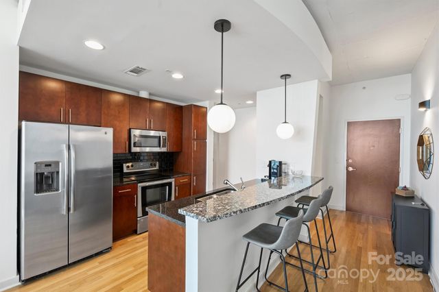 a kitchen with kitchen island a counter space a sink appliances and cabinets