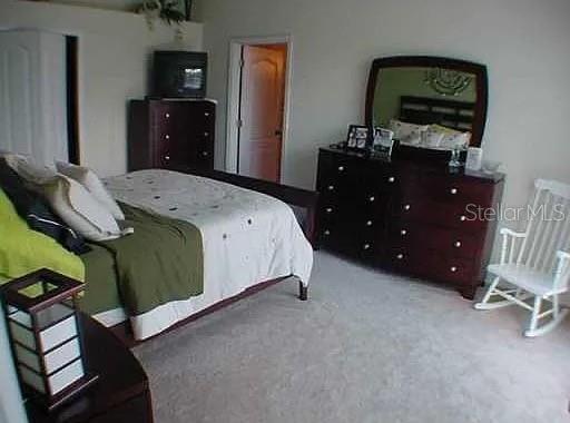 1237 Portmoor Way Winter Garden, FL 34787 - Photo 7 of 9 a bedroom with a bed and a dresser