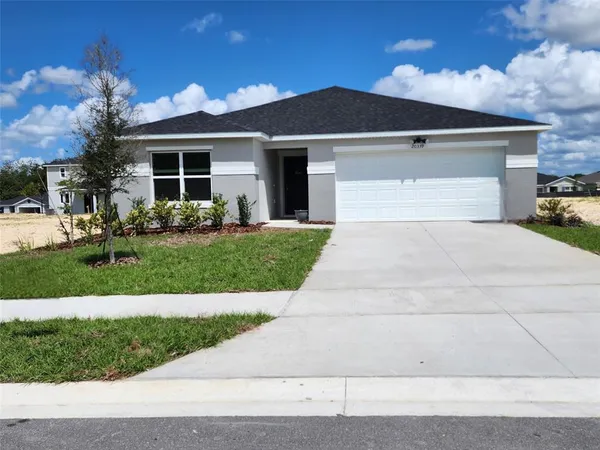 a front view of a house with a yard and garage