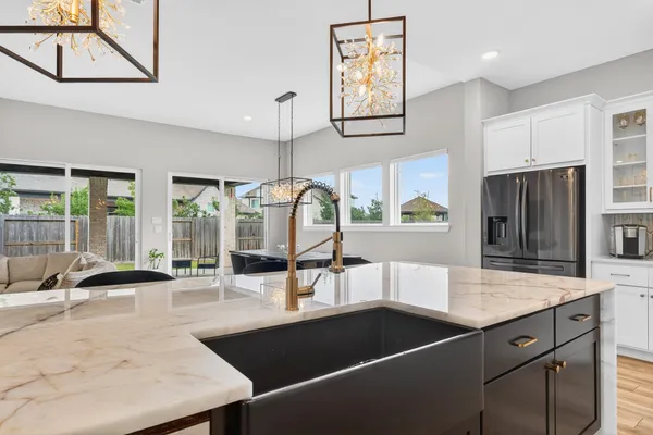 a large kitchen with stainless steel appliances kitchen island granite countertop a sink and a stove