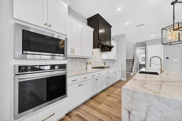 a large kitchen with stainless steel appliances kitchen island granite countertop a sink and cabinets