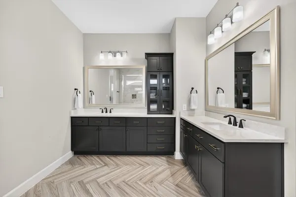a en suite bathroom with a double vanity sink and a mirror