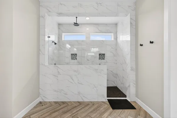 a bathroom with a bathtub shower sink mirror vanity and toilet