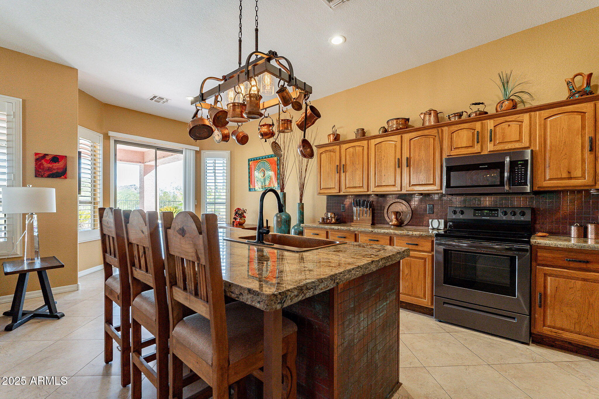 4333 South Pony Rider Trail Gold Canyon, AZ 85118 - Photo 17 of 54 a kitchen with stainless steel appliances granite countertop a stove top oven a sink dishwasher a dining table and chairs with wooden floor