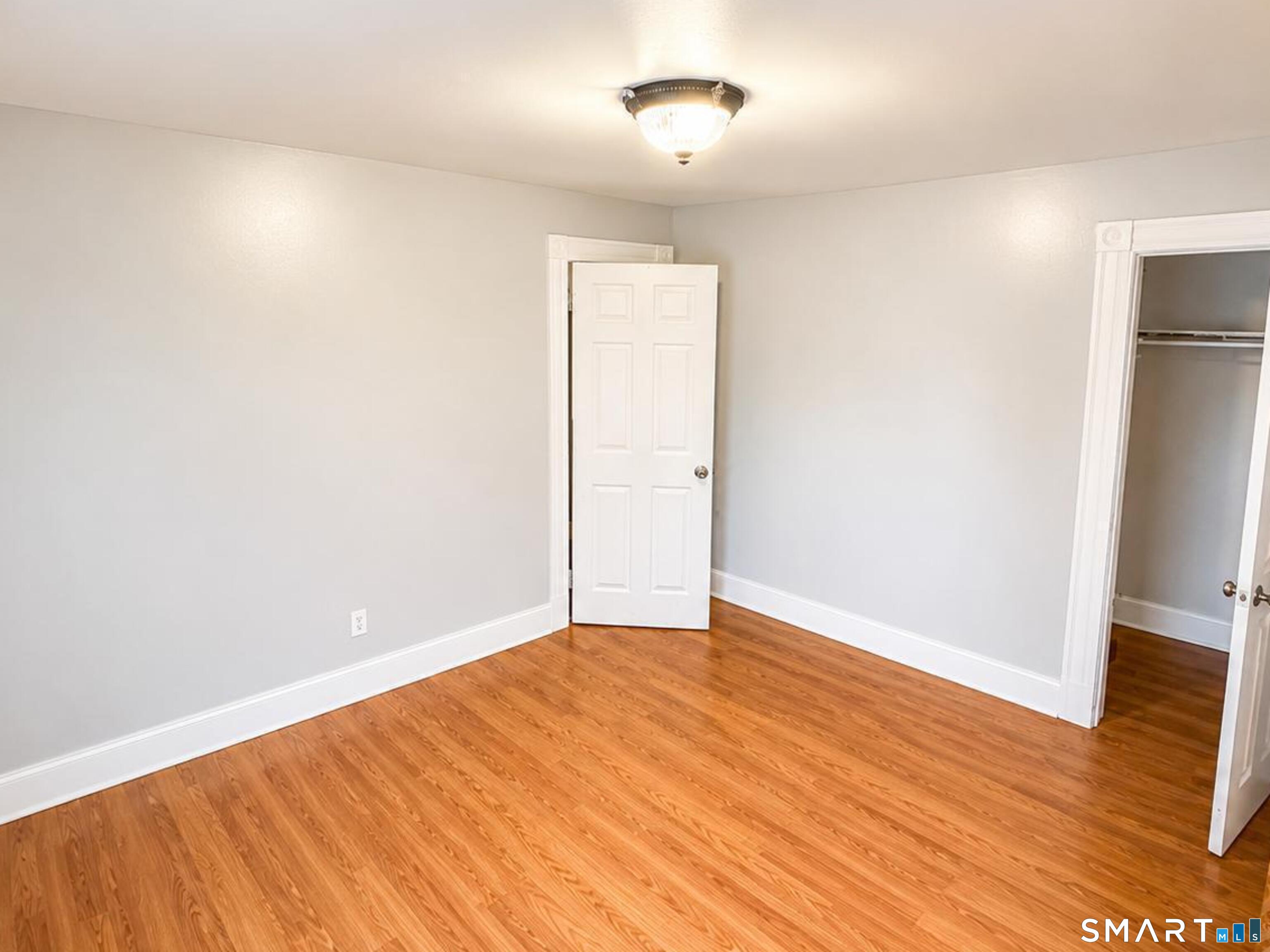 98 Huntington Road Bridgeport, CT 06608 - Photo 13 of 15 an empty room with wooden floor and entrance