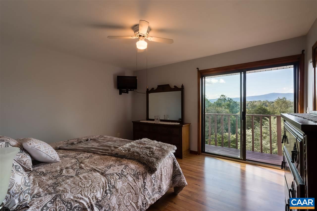 1655 Swift Run Road Ruckersville, VA 22968 - Photo 12 of 32 a bedroom with a large bed and a chandelier