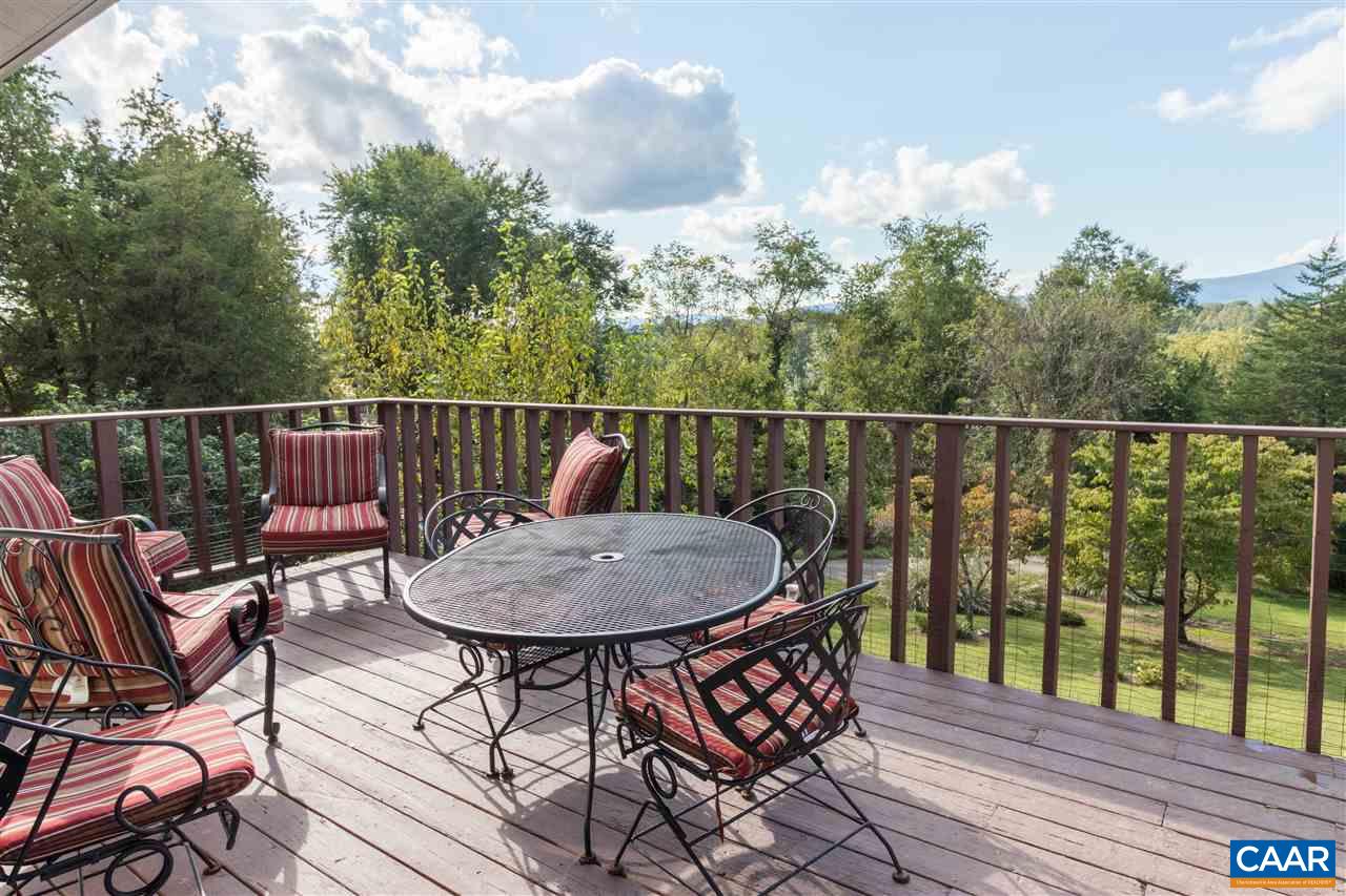 1655 Swift Run Road Ruckersville, VA 22968 - Photo 4 of 32 a balcony with wooden floor table and chairs