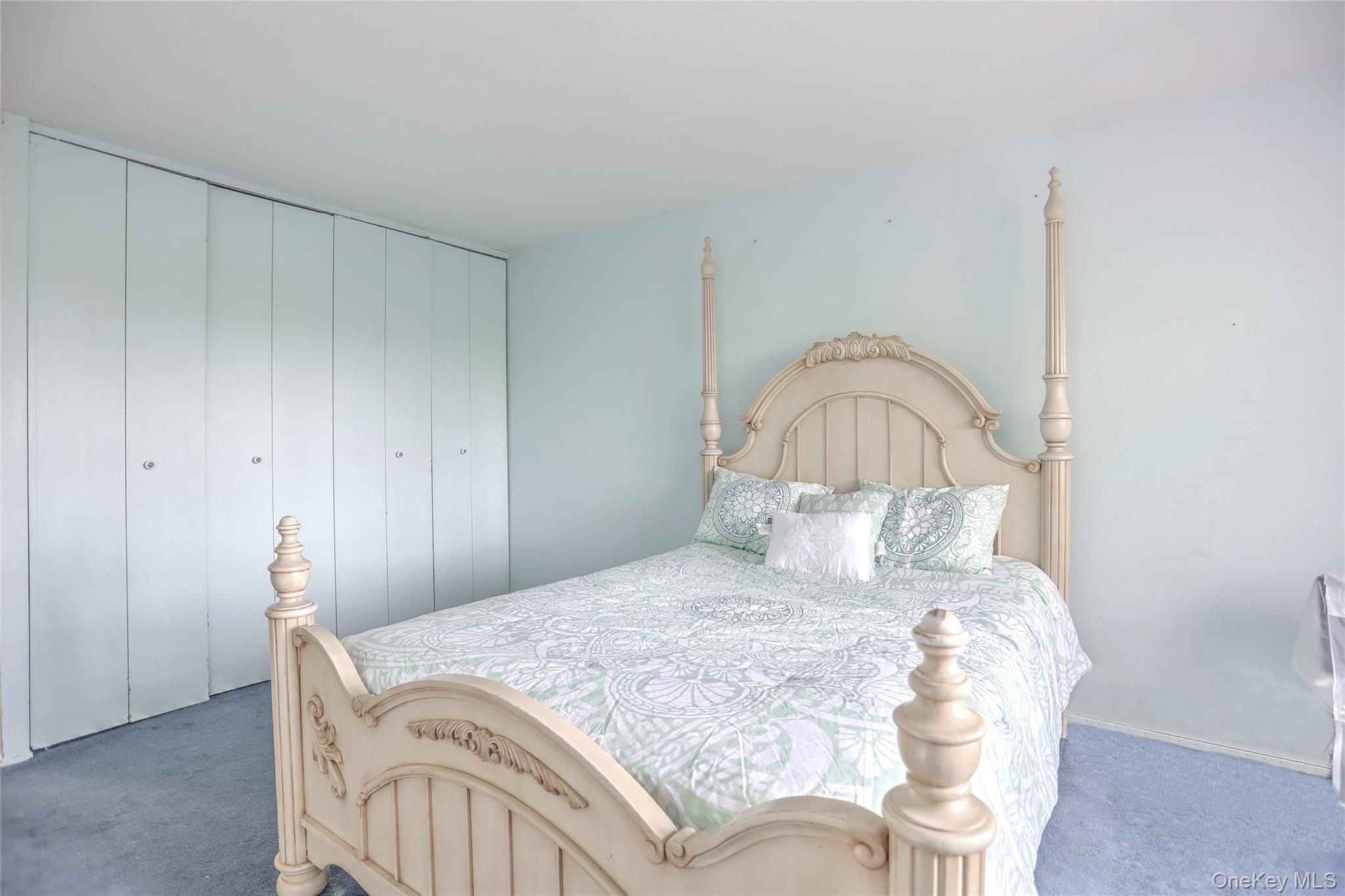 5 Secora Road, Unit F7 Spring Valley, NY 10977 - Photo 15 of 26 a bedroom with a bed and a table