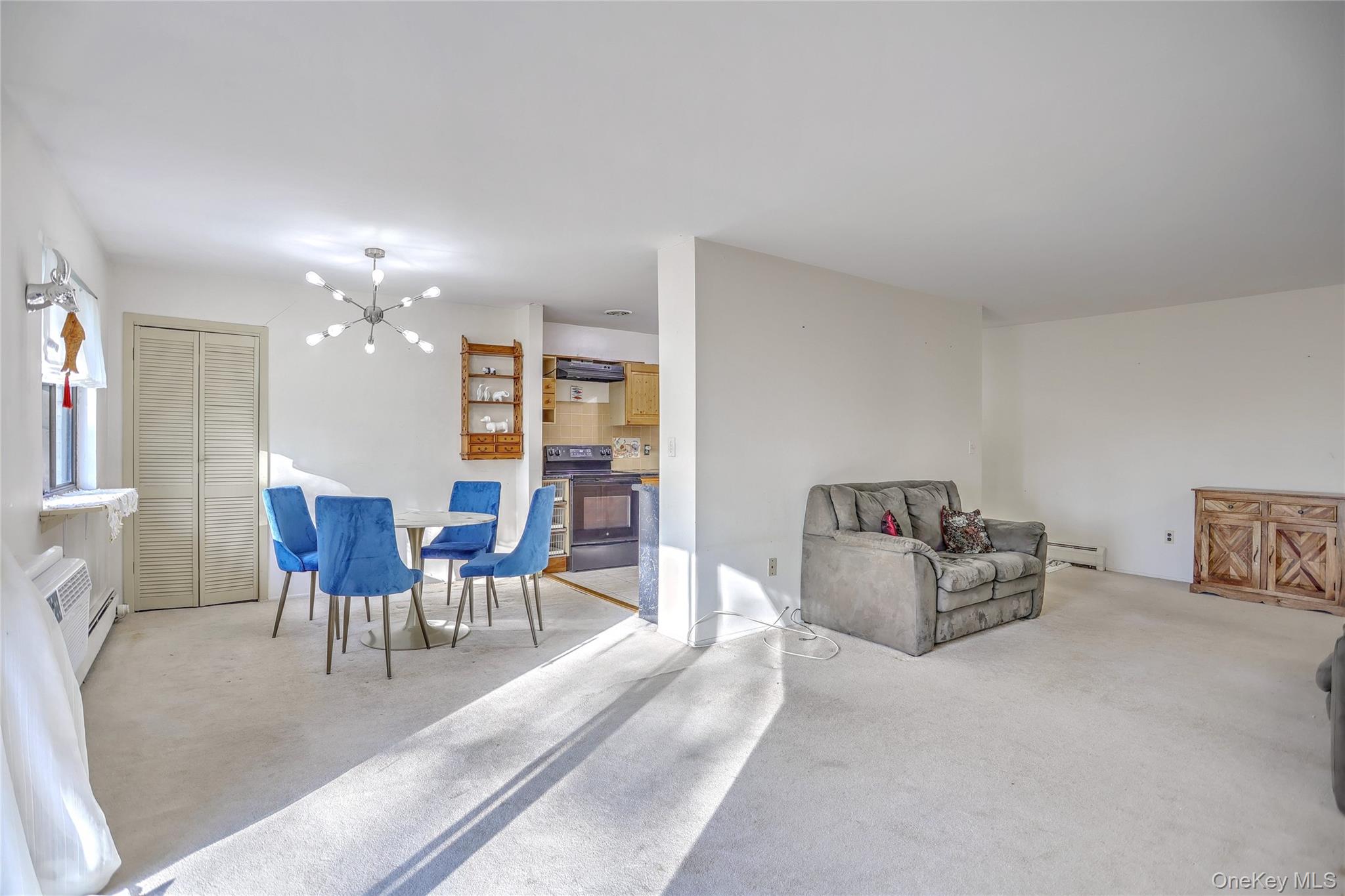 5 Secora Road, Unit F7 Spring Valley, NY 10977 - Photo 7 of 26 a dining room with furniture and chandelier