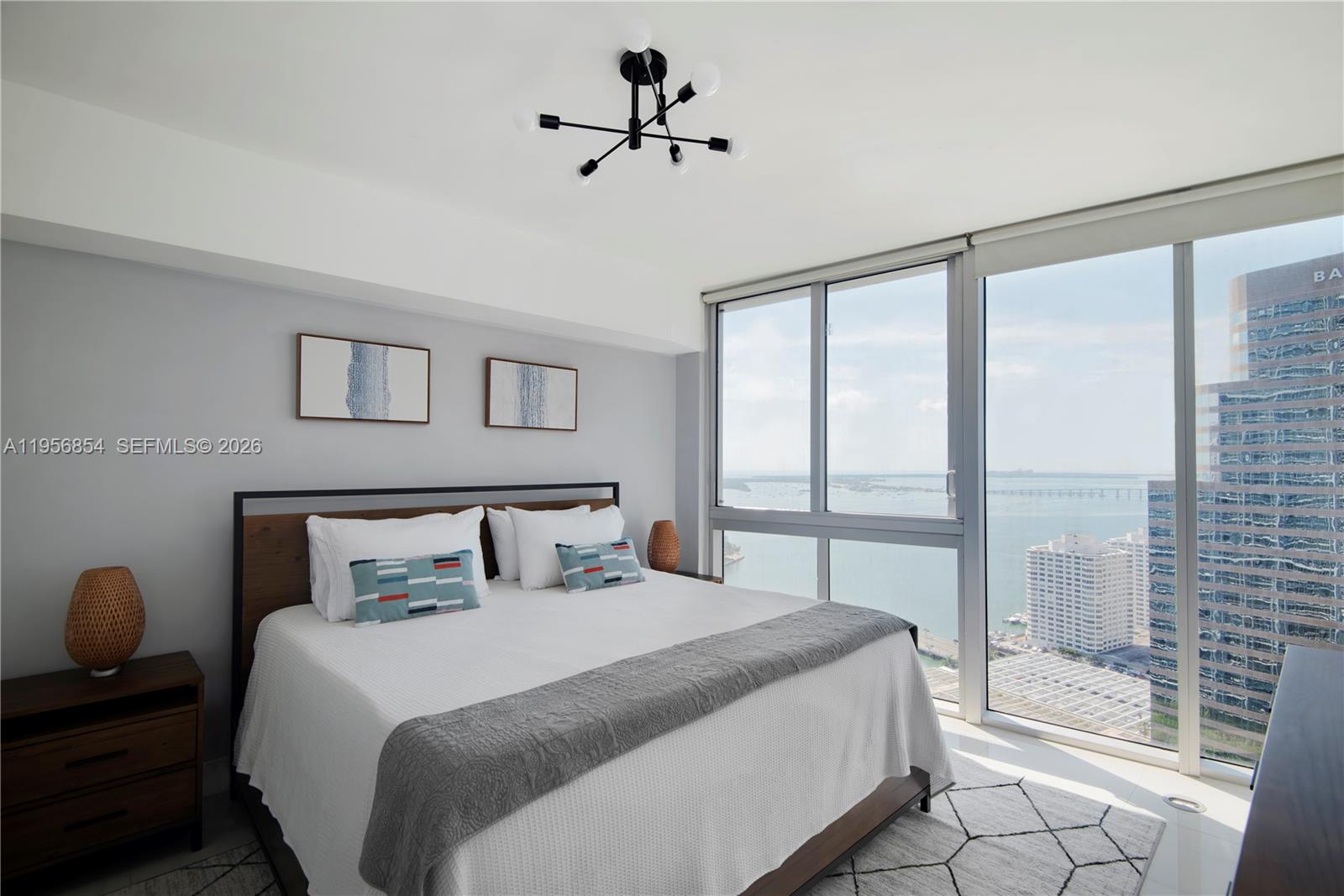 485 Brickell Avenue, Unit 3208 Miami, FL 33131 - Photo 20 of 29 a bedroom with a large bed and a chandelier fan