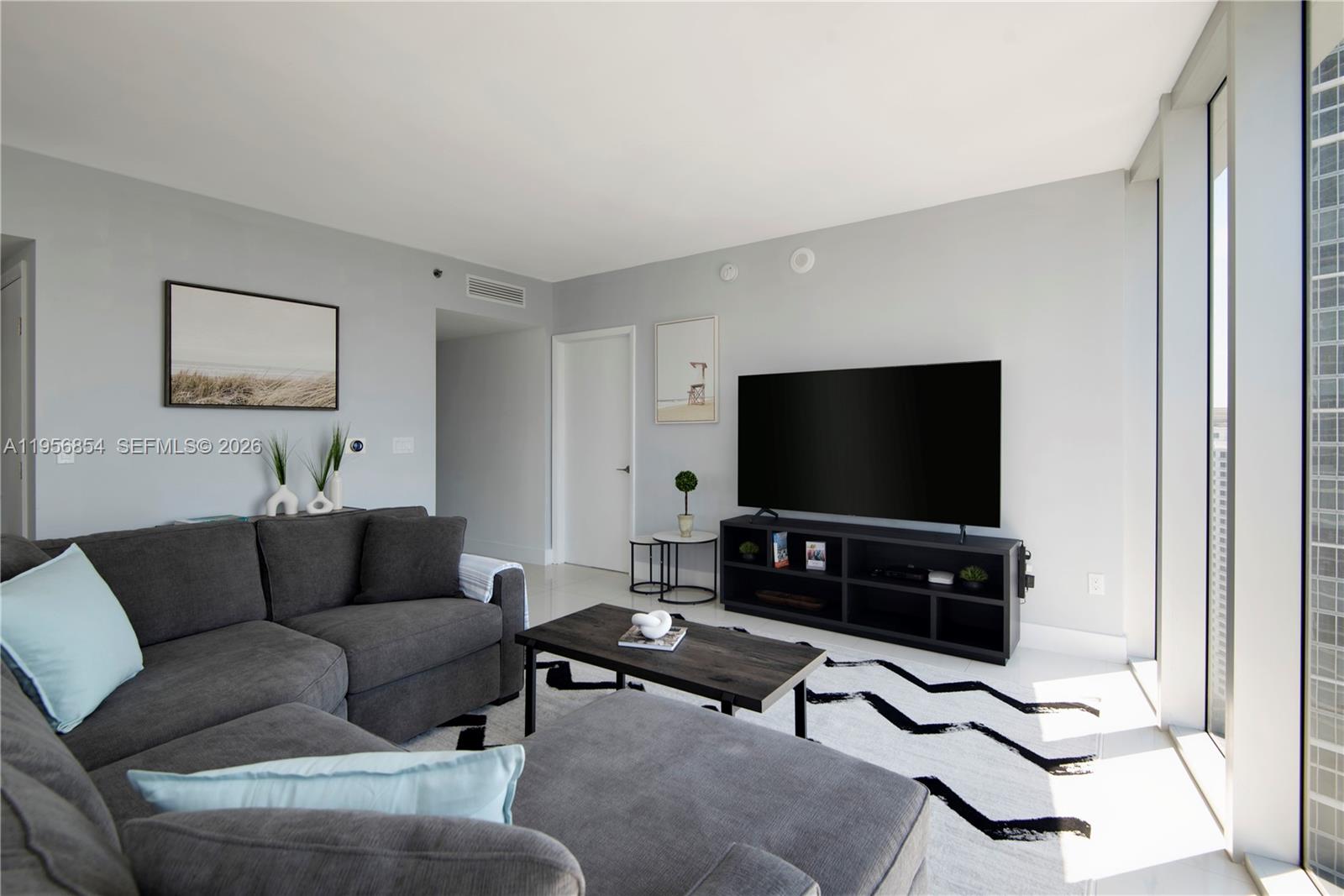 485 Brickell Avenue, Unit 3208 Miami, FL 33131 - Photo 3 of 29 a living room with furniture and a flat screen tv