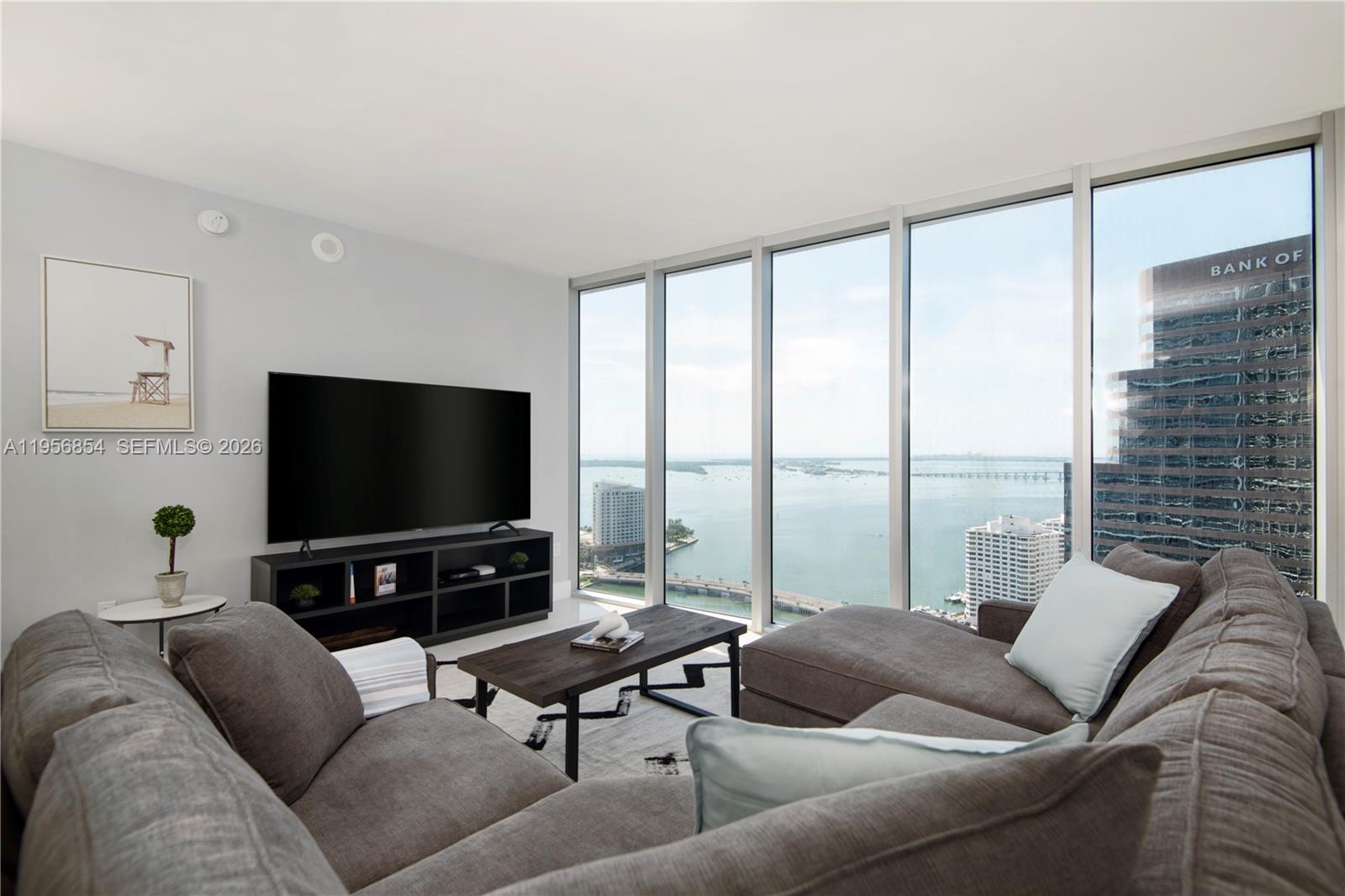 485 Brickell Avenue, Unit 3208 Miami, FL 33131 - Photo 6 of 29 a living room with furniture and a flat screen tv