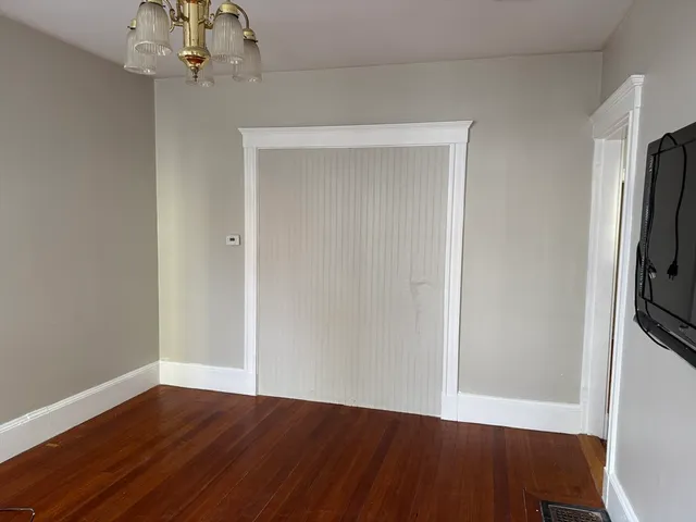 a view of a room with wooden floor and chandelier