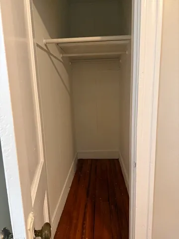 a small space in closet with wooden floor