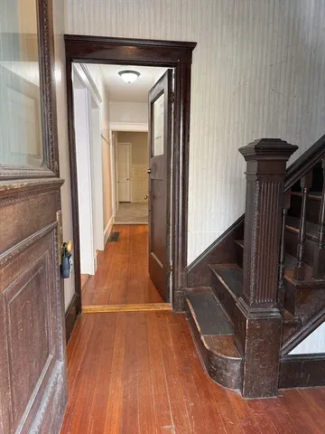 a view of a livingroom with wooden floor and staircase