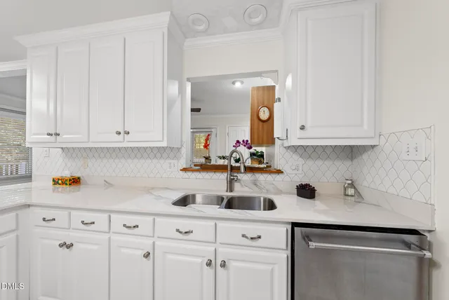a kitchen with white cabinets and appliances