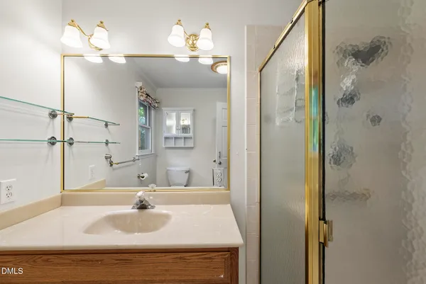 a bathroom with a sink a toilet and a mirror