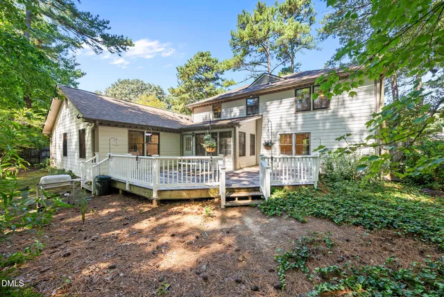 a backyard of a house with a garden a deck and barbeque oven