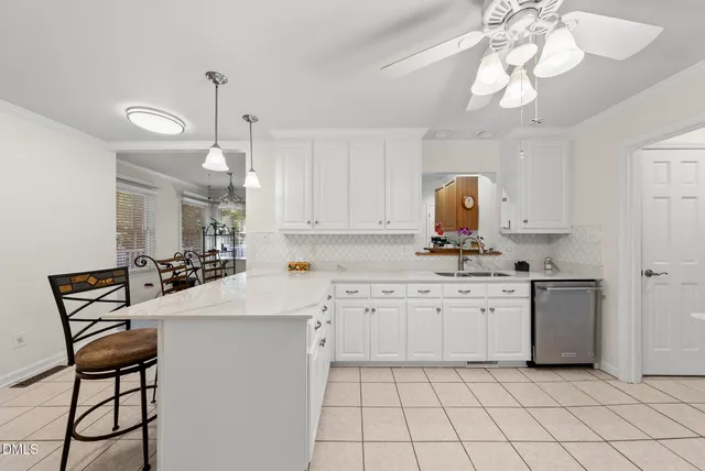 a kitchen with white cabinets and sink
