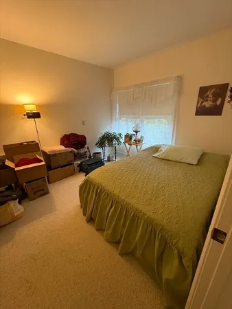 a spacious bedroom with a bed and a lamp