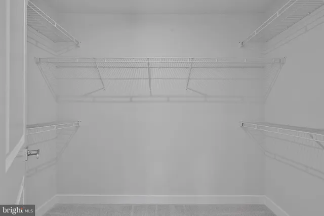 an empty room with ceiling fan and window