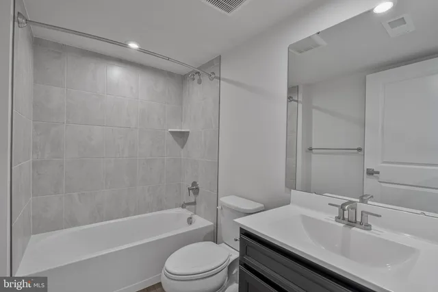a bathroom with a bathtub shower sink vanity and toilet