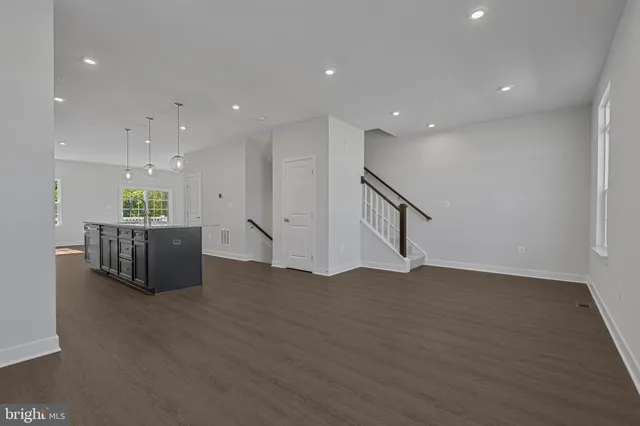 a living room with stainless steel appliances kitchen island furniture and wooden floor