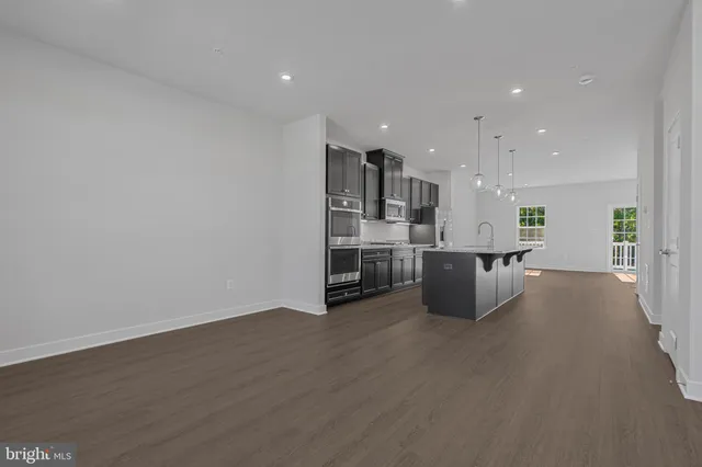 a view of kitchen and kitchen with stainless steel appliances wooden floor