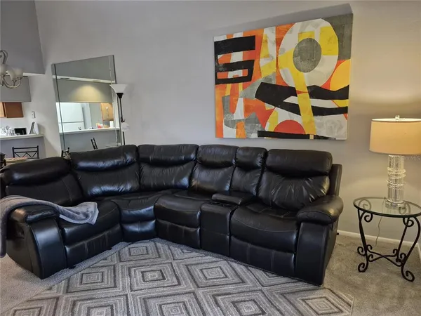 a living room with furniture and painting on the wall
