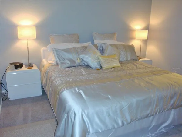 a large bed sitting in a bedroom next to a lamp