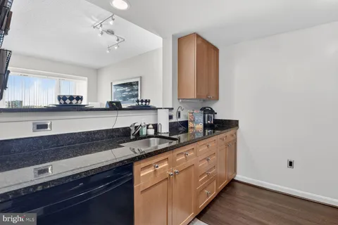 a kitchen with granite countertop white cabinets and white appliances