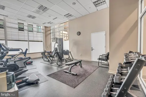 a dining hall with stainless steel appliances granite countertop a table chairs and couches with wooden floor