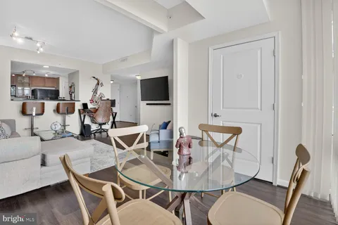 a living room with furniture a flat screen tv and kitchen view