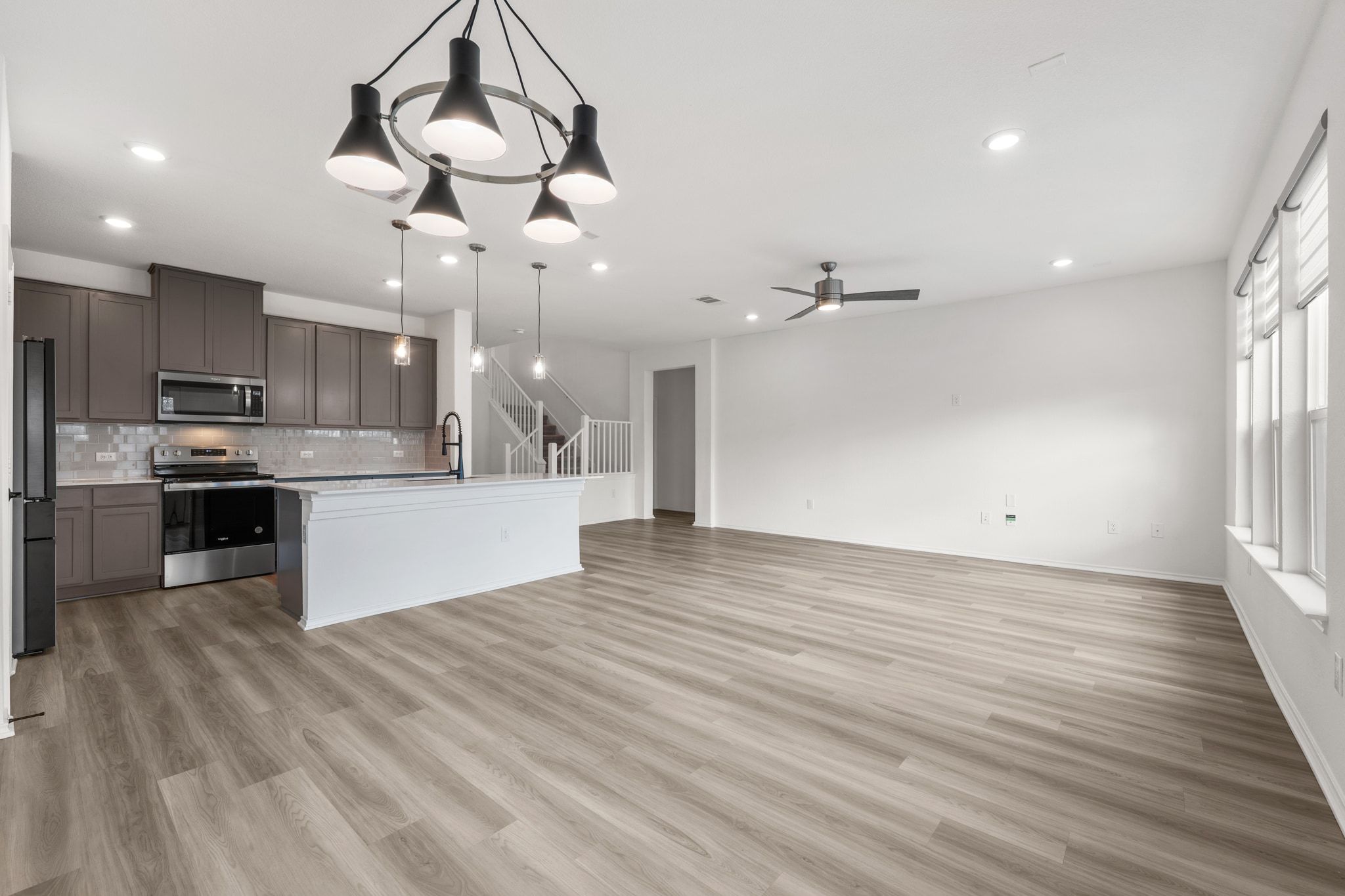 7715 Libretto Lane Austin, TX 78744 - Photo 38 of 39 The open concept floor plan allows ample room for both living and dining areas under tall ceilings with recessed lighting and a stylish modern chandelier.