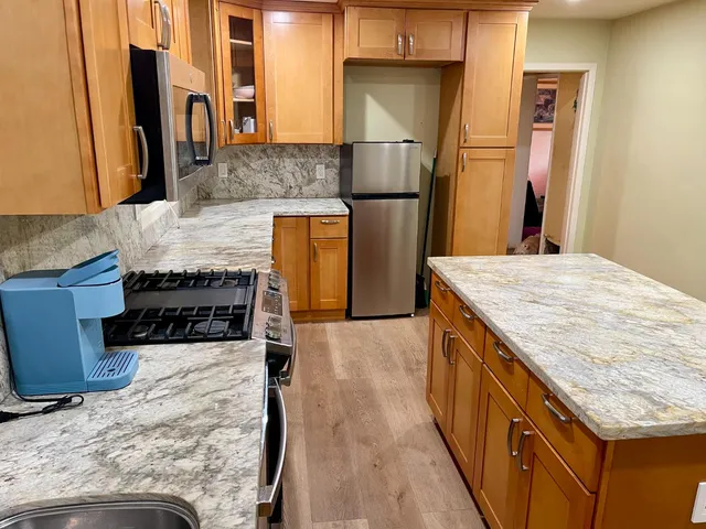 a kitchen with granite countertop stainless steel appliances and wooden cabinets