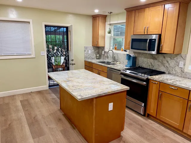 a kitchen with granite countertop cabinets appliances and a counter top space
