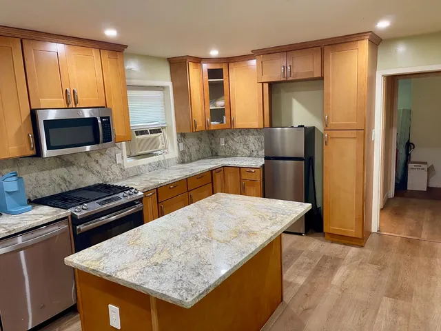 a kitchen with stainless steel appliances granite countertop a sink stove and refrigerator