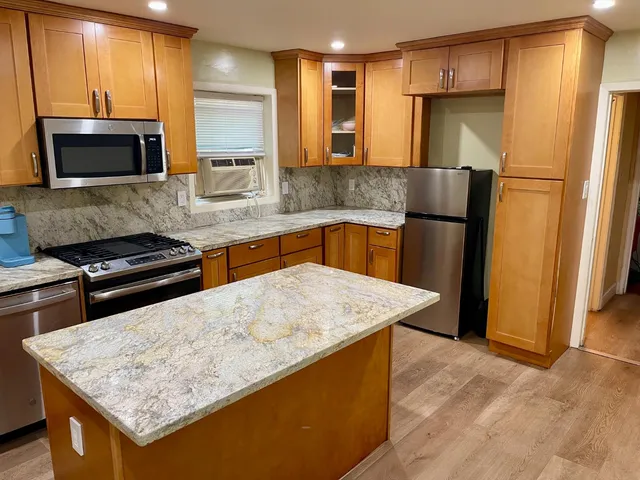 a kitchen with stainless steel appliances granite countertop a sink stove and refrigerator