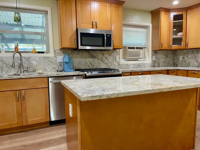 a kitchen with stainless steel appliances granite countertop a sink and a stove