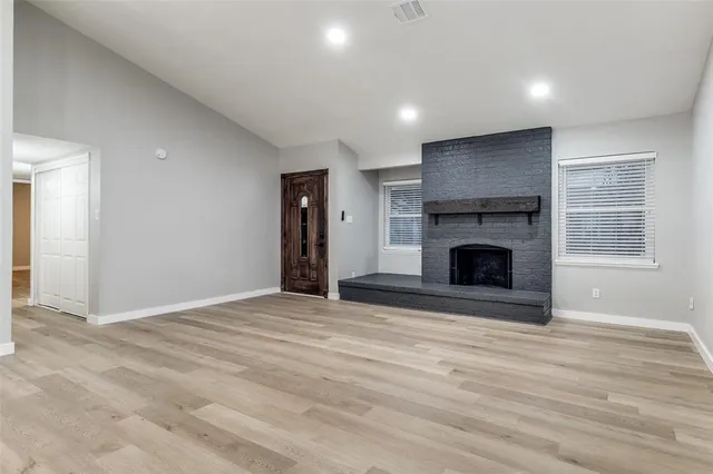 a view of empty room with wooden floor and fireplace