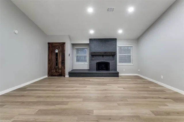 a view of an empty room with a fireplace and a window