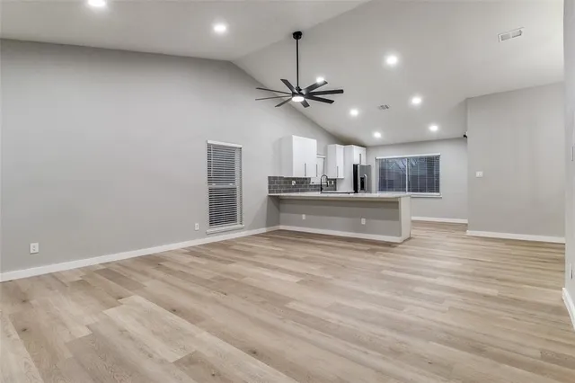 a view of a kitchen with a stove cabinets wooden floor and a ceiling fan