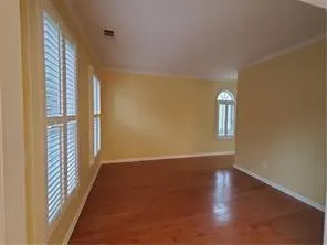 a view of a room with wooden floor and a window