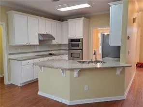 a kitchen with stainless steel appliances granite countertop a sink a stove and a refrigerator