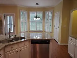 a bathroom with a granite countertop sink a window and a glass door