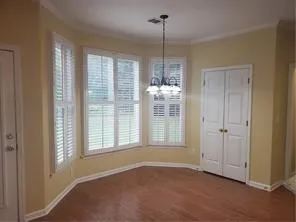 a view of an empty room with window and cabinet area