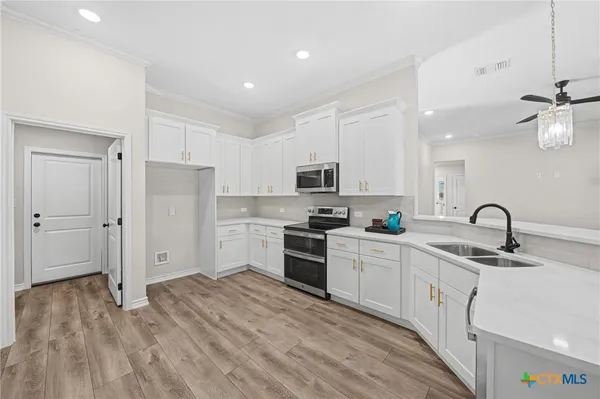 a kitchen with white cabinets and appliances