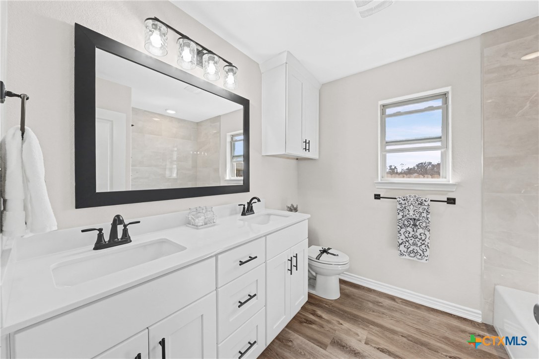 604 Magnolia Drive Troy, TX 76579 - Photo 19 of 33 a bathroom with a double vanity sink and a mirror